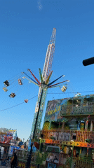 Fairground swing ride operates in Great Yarmouth on sunny day