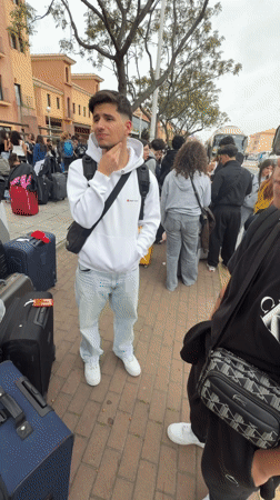 Young travelers with luggage wait for transport in Punta Umbría