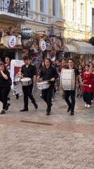 Drum group marches through urban commercial district