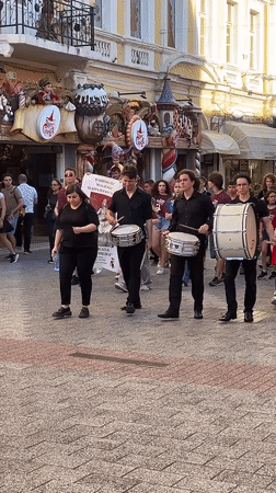 Drum group marches through urban commercial district