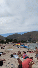 Crowded beach day at Palermo's Mondello under cloudy skies