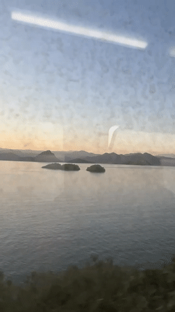 Train passenger views serene lake with islands near Vranjina