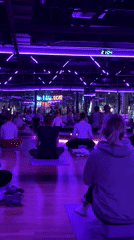 Group practices yoga in purple-lit studio