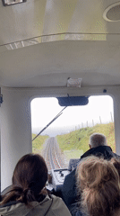 Small train carries passengers through Welsh countryside near Llanberis