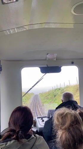 Small train carries passengers through Welsh countryside near Llanberis