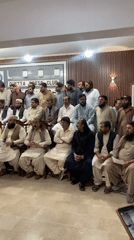 Men gather for apparent press conference or public meeting