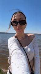 Woman enjoys sunny morning with dog by lake in Votkinsk