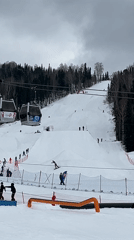 Snowboarders perform rail tricks at ski resort early morning