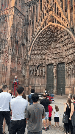 Acrobats perform outside Strasbourg Cathedral on a summer evening