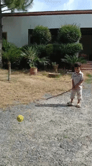 Child plays improvised cricket in Pakistani village driveway