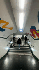 Four people climb subway stairs in Paris Metro tunnel