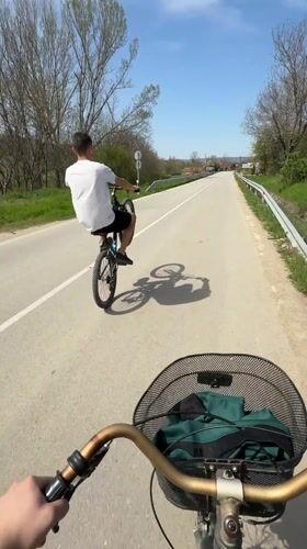 Cyclist performs wheelie on road in Djulunitsa, Bulgaria