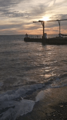 Sochi's pebble beach and pier at sunset