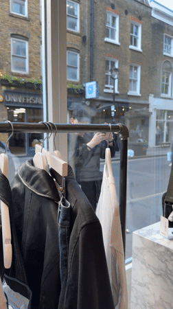 Man enters London shop carrying small black dog