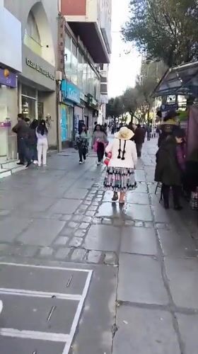 Pedestrians walk along La Paz street in evening hours
