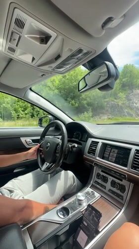 Couple drives through Montenegro hills, woman gestures from passenger seat