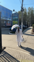 Woman in all-white outfit walks through Chaikovsky, Russia dawn