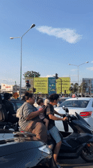 Family waits on motorcycle at Thai intersection
