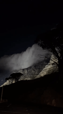 Table Mountain illuminated at night, Cape Town skyline visible