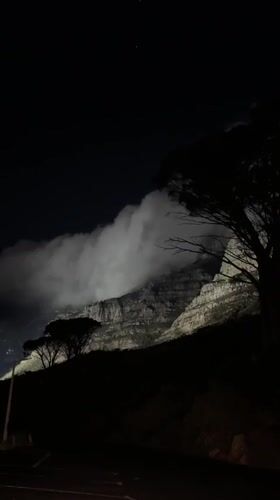 Table Mountain illuminated at night, Cape Town skyline visible