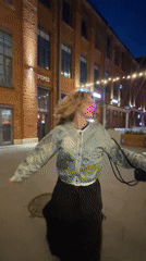 Woman dances, changes shoes near vintage bus in Saint Petersburg