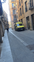 Ambulance with flashing lights responds on narrow Barcelona street