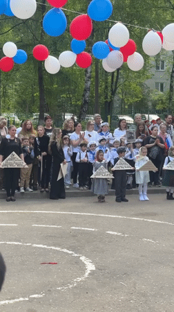 Children hold triangular objects at outdoor gathering in Shulgino