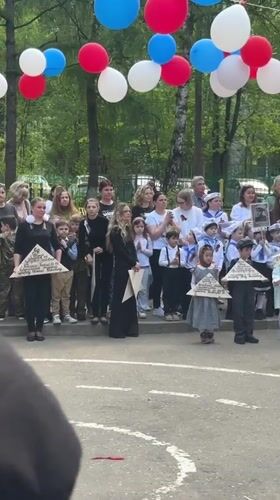 Children hold triangular objects at outdoor gathering in Shulgino