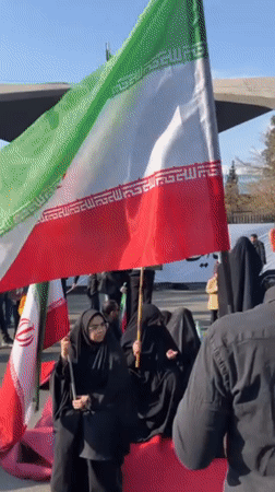 Demonstration with chador-clad women holding Iranian flags in Tehran