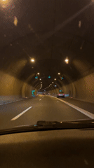Vehicle travels through lit highway tunnel in Ljubljana