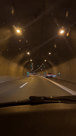 Vehicle travels through lit highway tunnel in Ljubljana