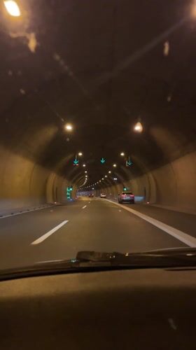 Vehicle travels through lit highway tunnel in Ljubljana