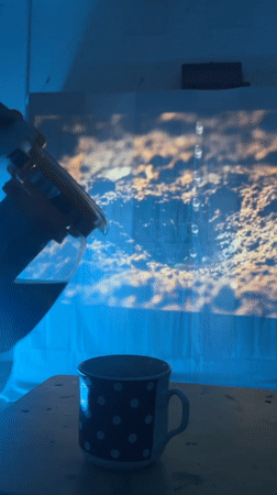 Dark liquid poured into mug under blue lights in Ukraine