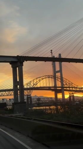Vehicle passenger films bridges during sunset in New Westminster