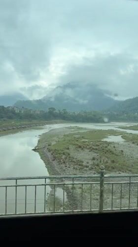 River valley view documented in cloudy Damauli, Nepal