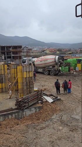 Construction crew supervises cement mixer operations in Markovo