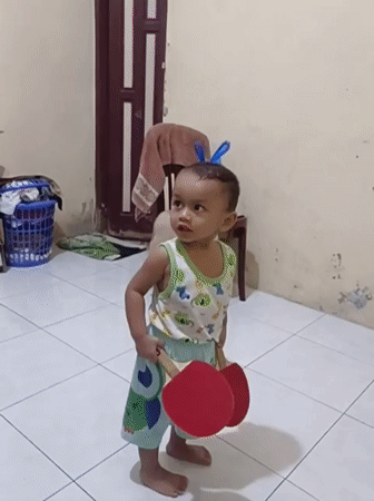 Toddler moves between play and prayer at home in Blang Cut