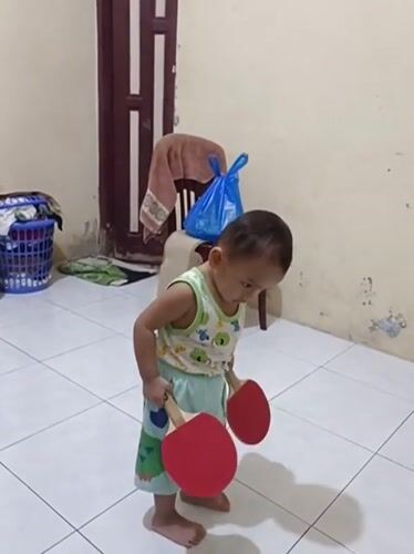 Toddler moves between play and prayer at home in Blang Cut