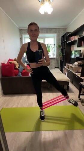 Resistance band leg workout on a green yoga mat indoors