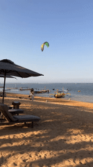 Bali beach morning: kites, outriggers, and calm water
