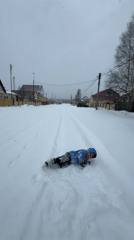 Child plays in deep snow on residential street in Russia