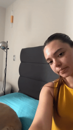 Woman records herself with dog in Mexican bedroom