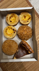 Pastry box opened revealing egg tarts, cream puffs in Kudrovo