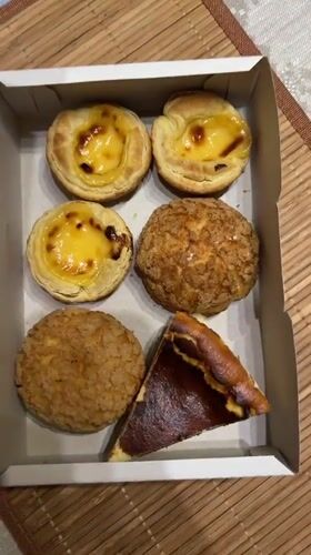 Pastry box opened revealing egg tarts, cream puffs in Kudrovo