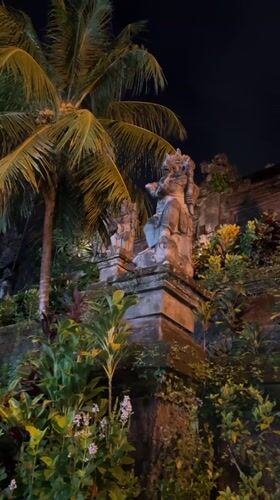 Nighttime temple statues illuminated in Ubud, Bali