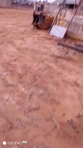 The video pans across a dirt-covered area with piles of long, teal-colored metal pieces. The background shows indistinct construction materials. The camera movement is shaky, and the video appears to be taken with a cell phone. The "itel P40 4G" watermark is visible.