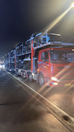 Car carrier truck transports new vehicles through Russian town