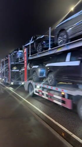 Car carrier truck transports new vehicles through Russian town