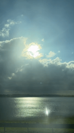 Sunbeams over lake captured from vehicle in Linevo, Russia