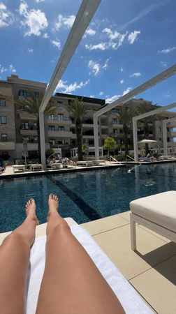 Person enjoys poolside relaxation at Tivat resort facility